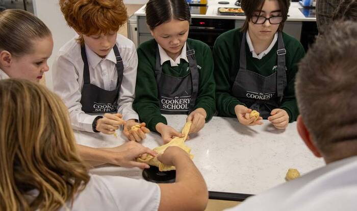 Pupils making pizza in a cookery class